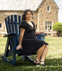 Jennifer Sontay sitting on a chair in front of a brick building